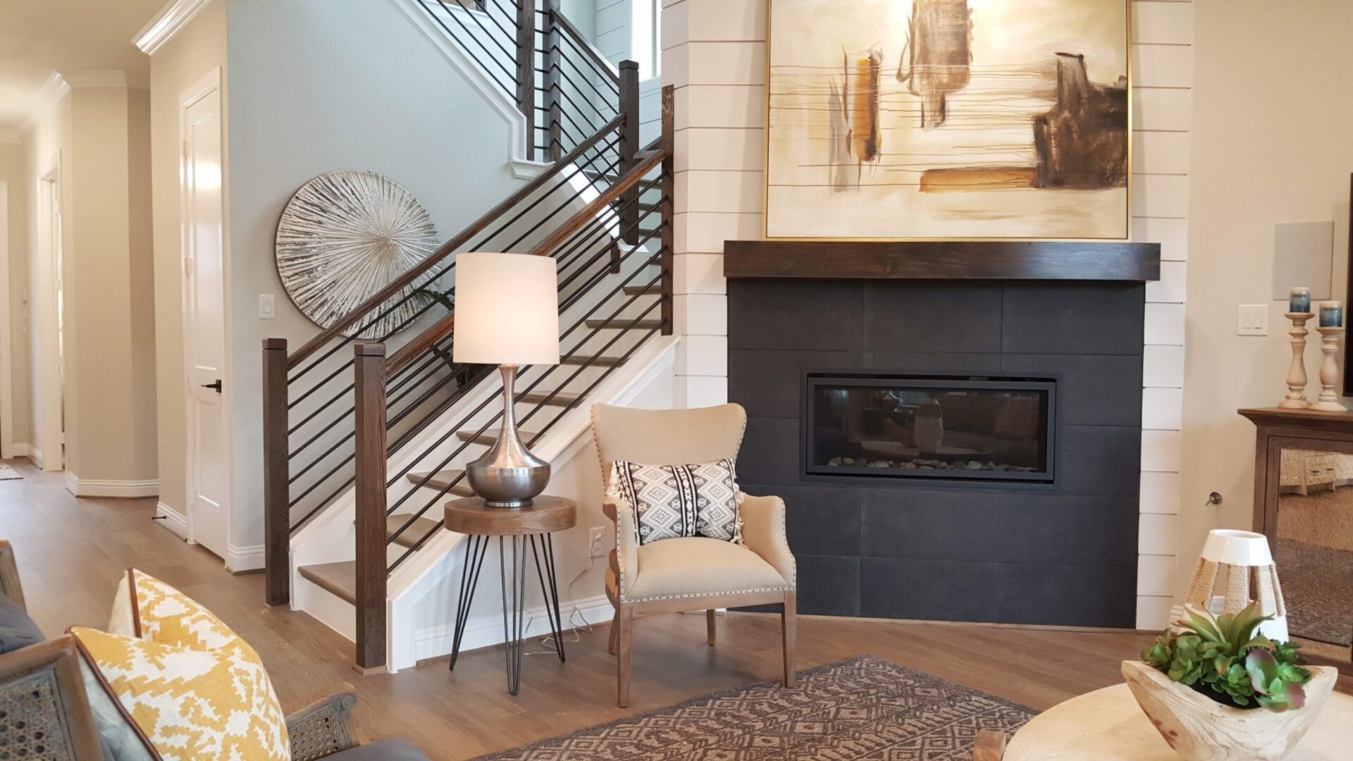 A living room with a fireplace and stairway.