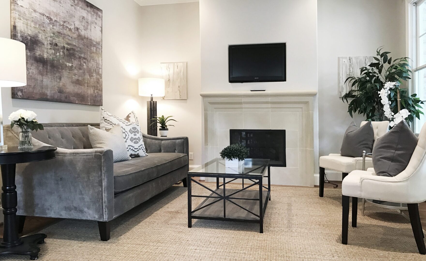 A living room with gray furniture and a fireplace.