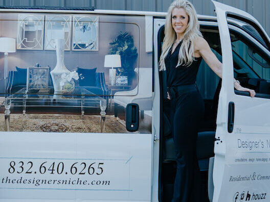 A woman standing in front of a van with a sign on it.