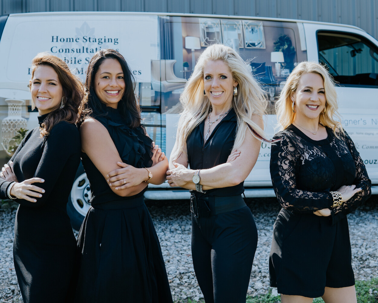 Four women standing in front of a van.