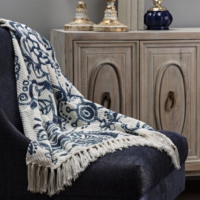 A chair with a blue and white throw in front of it.