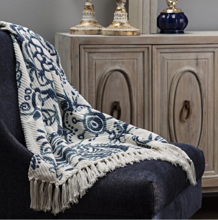 A chair with a blue and white throw in front of it.